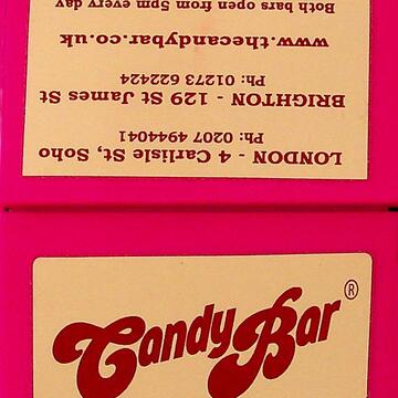 Small pink plastic box/ cards holder. Text contains contact information and address details for both the Brighton and London locations. 